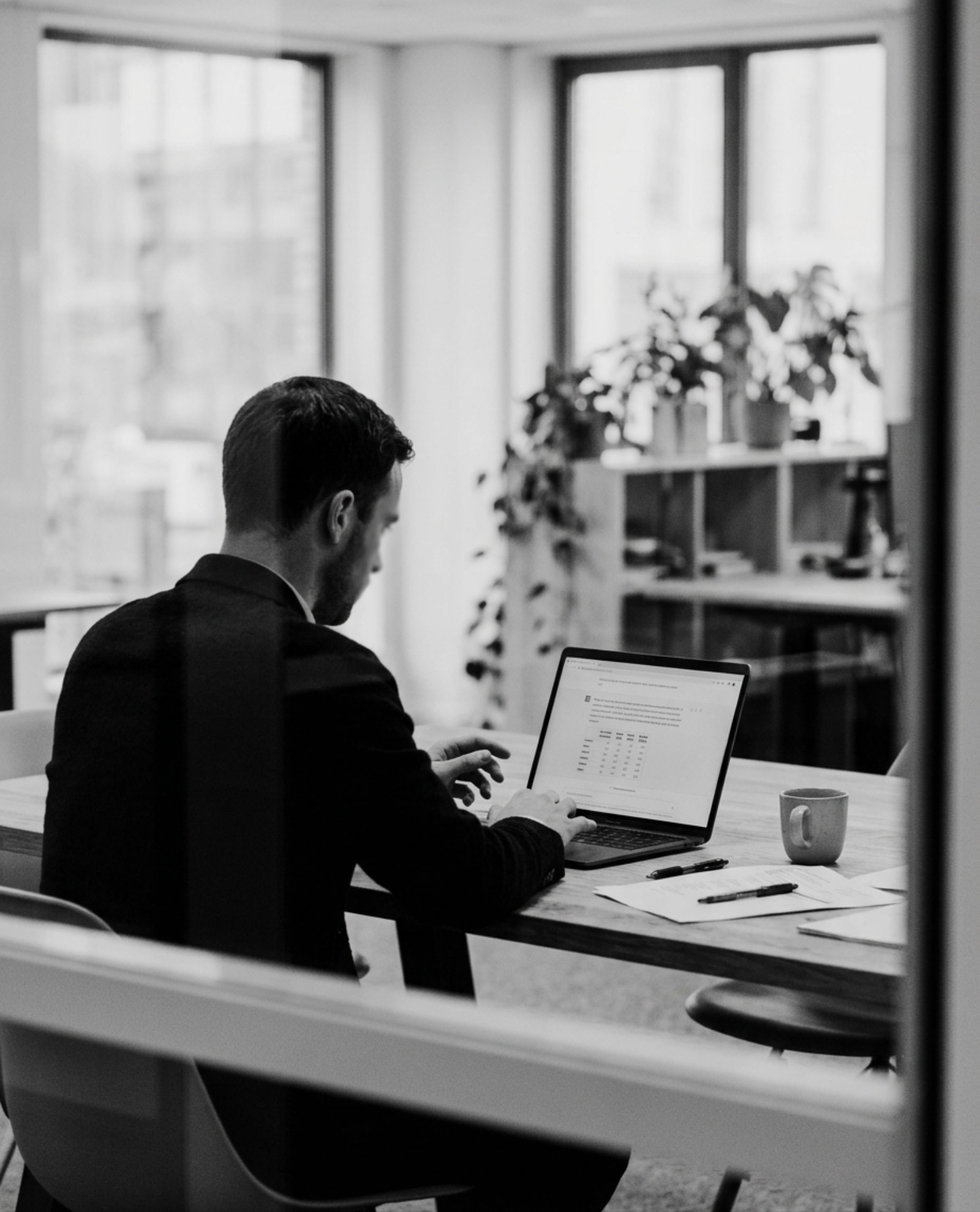 Een medewerker stelt een vraag aan de assistent op zijn laptop