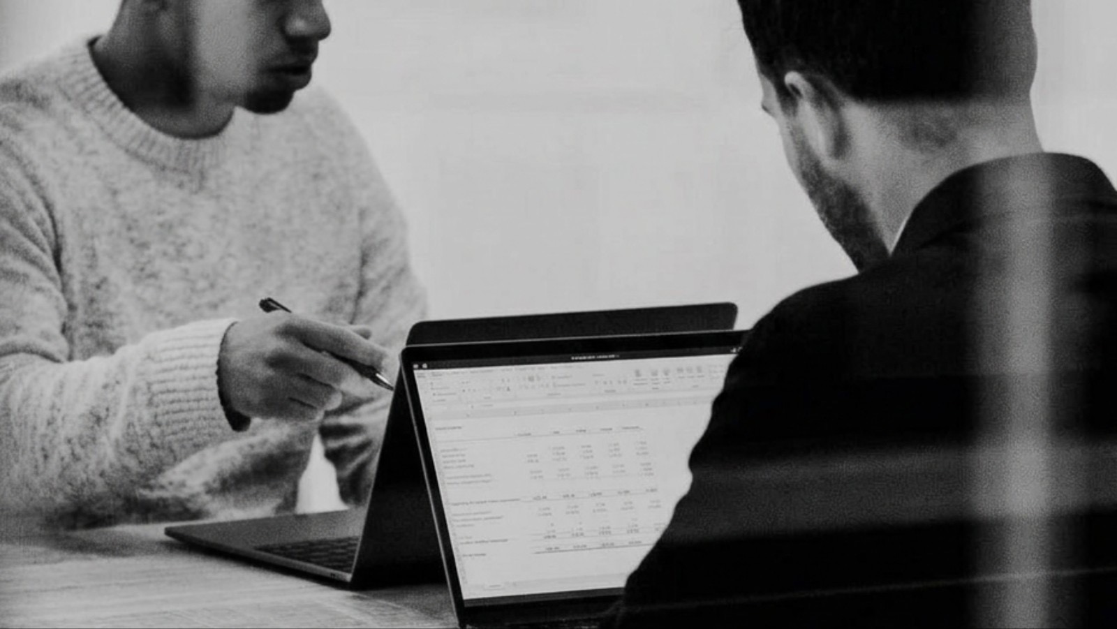 Twee collega's bekijken samen een berekening op een laptop
