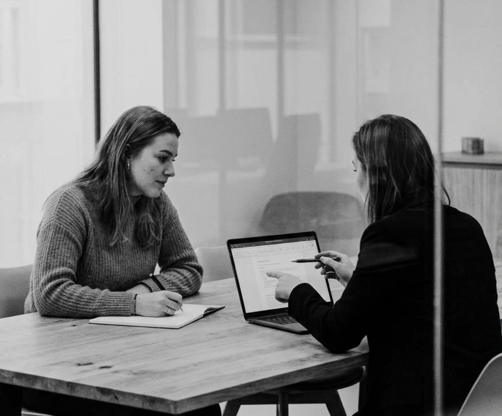 Twee collega's beoordelen samen een antwoord op een laptop